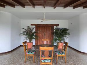 a dining room with a table and four chairs at Finca Hotel Galilea Doradal in Doradal
