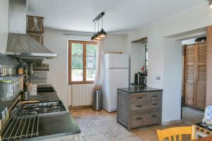 eine Küche mit einem weißen Kühlschrank und einem Herd in der Unterkunft La Maison Dauphinoise in Saint-Bueil