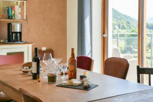 einen Holztisch mit Weinflaschen und Gläsern darauf in der Unterkunft La Maison Dauphinoise in Saint-Bueil + 26 Fotos