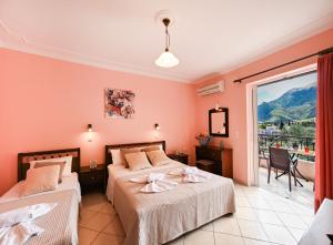 a bedroom with two beds and a balcony at Sunrise studios Lefkada in Nydri +67 photos