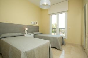 マルベーリャにあるVillas Altos De Marbellaのベッド2台と窓のある寝室 +37枚の写真