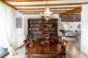 a dining room with a wooden table and chairs at Luxurious Seafront Villa in Pefkohori in Pefkochori
