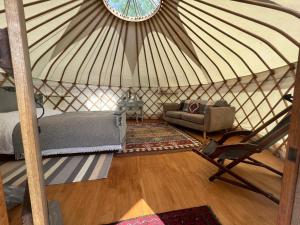 a bedroom in a yurt with a bed and a chair at Hinton land glampsite in Peterchurch +17 photos