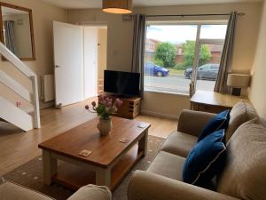 a living room with a couch and a coffee table at Beautiful home near to Musgrove Park Hospital in Taunton