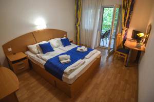 a bedroom with a large bed with towels on it at Amore Apartmanhaz in Siófok