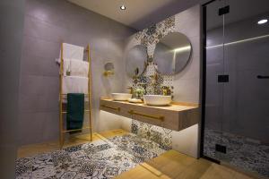 a bathroom with two sinks and two mirrors at Al Marmoom Oasis Luxury Experiential Desert Resort in Dubai