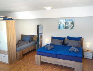 ein Schlafzimmer mit einem blauen Bett und einem Spiegel in der Unterkunft Villa Dupin Oceanfront with boat dock in Bobovišća