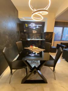 Un comedor con una mesa y sillas negras. en King Lux Apartment, en Skopje