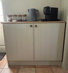 a white cabinet with a coffee maker on top of it at The Annexe at Fishponds in Glastonbury +38 photos