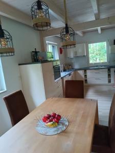 einen Tisch mit einer Schale Obst auf einem Teller in der Unterkunft Luxus Summer Breeze Ferienhaus Lübbesee Sauna Bootssteg Templin in Milmersdorf + 19 Fotos