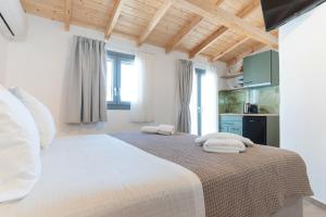 a bedroom with a large white bed with towels on it at Lelis Studios in Pythagoreio