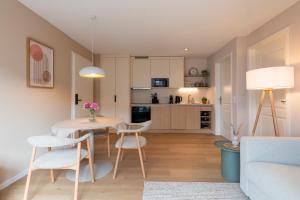 a living room and kitchen with a table and chairs at Adler Apartments in Ettenheim