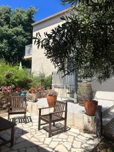 un patio con 2 panche e un albero di Village Cargèse 2 a Cargèse