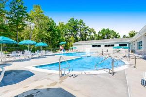 a swimming pool with chairs and umbrellas at Sea Colony --- 3201 Round Robin in Bethany Beach