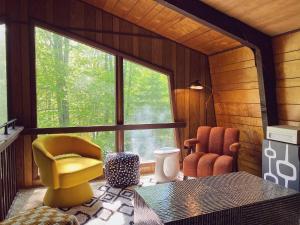 een kamer met een gele stoel en een groot raam bij Designer Poconos Chalet I Ski, Skate, Lakes, Family-Friendly in Lake Ariel