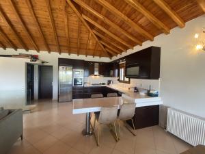 cocina con techos de madera, mesa y sillas en Runway Mansion, stunning views and lots of space, en Skiathos