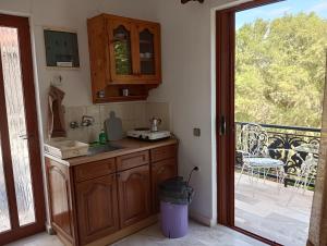 a kitchen with a sink and a door to a patio at renesis studios in Lithakia