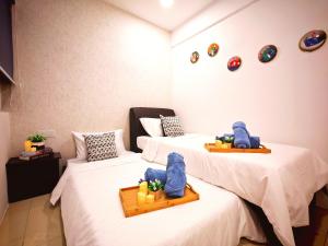 zwei Betten in einem Zimmer mit Handtüchern darauf in der Unterkunft Ipoh Manhattan Waterpark Suite by City Home Empire MHA306 in Ipoh