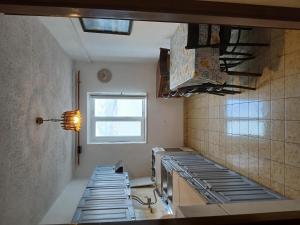 a kitchen with a row of stainless steel appliances at Apartments Sova in Postira