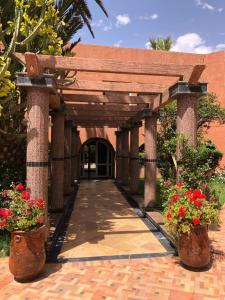 une entrée à un bâtiment avec deux plantes en pot dans l'établissement Tiznit Hotel, à Tiznit
