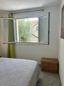 una camera da letto con un letto e una grande finestra di Village Cargèse 2 a Cargèse