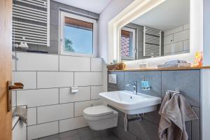 a bathroom with a white toilet and a sink at Storchenblick in Wunstorf +20 photos