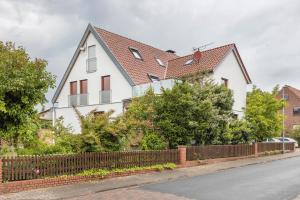 a white house with a fence on a street at Storchenblick in Wunstorf