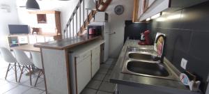 une petite cuisine avec un évier et un comptoir dans l'établissement Gites Vert à la mer climatisation dans toutes les pièces, à Port-la-Nouvelle
