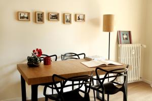 a dining room table with chairs and pictures on the wall at Flowers Rooms - Ponte Milvio in Rome