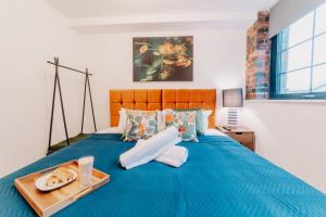 a blue bed with a tray of food on it at Luxury Two Bedroom Birmingham City Centre Apartment in Birmingham