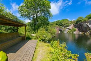 a wooden deck with a view of a river at Costentyn, Tor Down Quarry in Bodmin