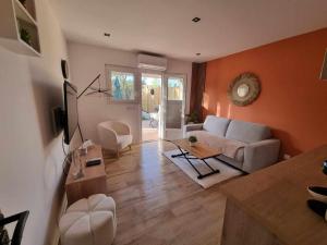 a living room with a couch and a table at Maison St Aygulf entre mer et détente in Fréjus