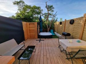 a wooden deck with a bench and a table at Maison St Aygulf entre mer et détente in Fréjus