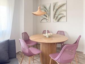 a dining room with a wooden table and purple chairs at ChillaHomes 003 in Candeleda +20 photos