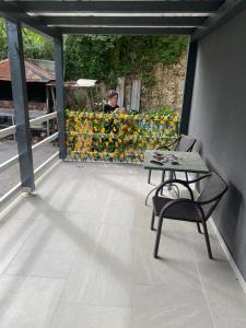 Ein Tisch und ein Stuhl auf einem Balkon mit Blumen in der Unterkunft Marshal 2 in Donja Ljusina
