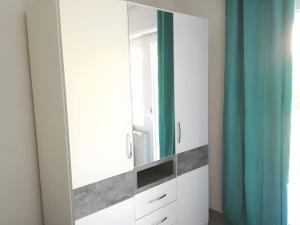 a dressing room with a mirror and blue curtains at Ferienwohnung Anna in Gaienhofen +19 photos