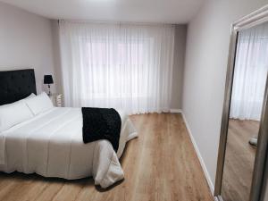 a bedroom with a white bed and a large mirror at Cangas con encanto in Cangas de Morrazo