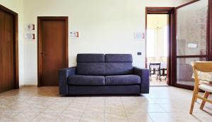 a blue couch sitting in a living room at Guest Holiday Alpi in Cadelbosco di Sotto