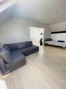 Una sala de estar con un sofá azul y una cama. en MaïTyNa - Tomorrowland Stay, en Rumst