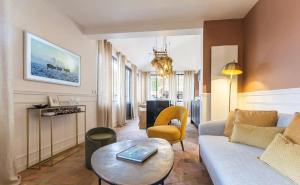 a living room with a couch and a table at La Petite Maison de Giverny - Chambres privées - Gîte 5 étoiles au Cœur du village in Giverny