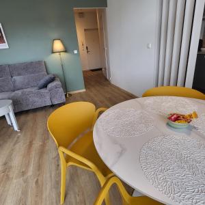 a living room with a white table and yellow chairs at Kastani Home 15 in Tartu