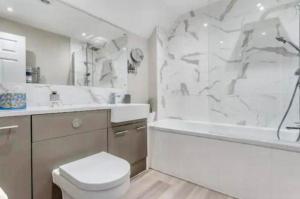 Un baño con inodoro, bañera y lavabo. en Stylish Poole townhouse, en Poole 1 foto más