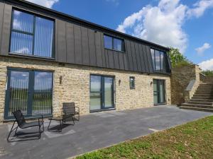 a house with two chairs and a table on a patio at Frogwell in Sherborne