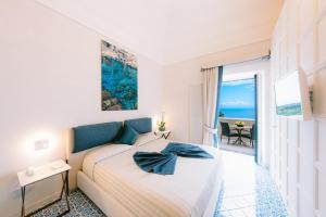 une chambre avec un lit et une vue sur l'océan dans l'établissement Palazzo Pascal, à Scala