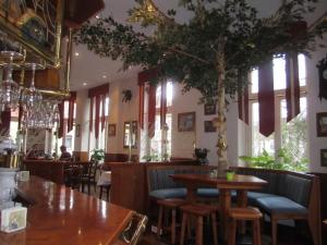 a restaurant with tables and chairs and a tree at Hotel Deutsches Haus Wolfen OHG in Wolfen