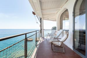 a balcony with chairs and a view of the ocean at GuestHost - Villa Vittoria - Casa sullo Scoglio in Mazzeo