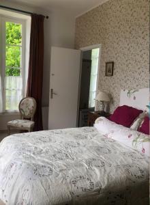 Un dormitorio con una cama grande y una ventana en La maison de Léandre - Medoc, en Saint-Seurin-de-Cadourne