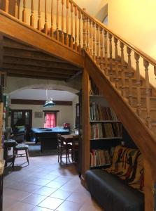 Una sala de estar con una escalera con una estantería. en La maison de Léandre - Medoc, en Saint-Seurin-de-Cadourne