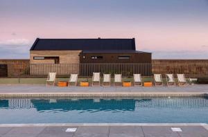 a group of chairs sitting next to a swimming pool at Cabu by the sea in Dymchurch