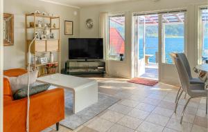 a living room with a couch and a tv at 3 Bedroom Awesome Home In Gursken in Larsnes